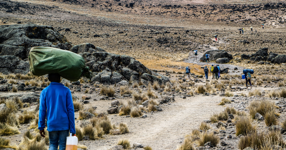 Porters carrying bags on route to Kilimanjaro summit.